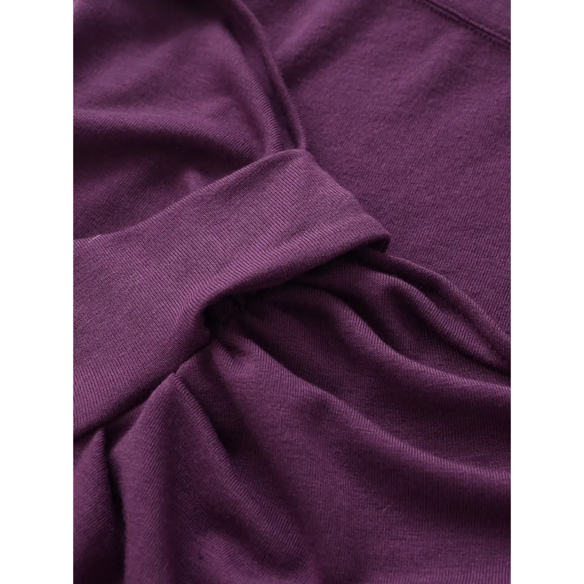 Close-up of the fabric on the purple twist-front top, showing the soft knit texture and gathered bust detail