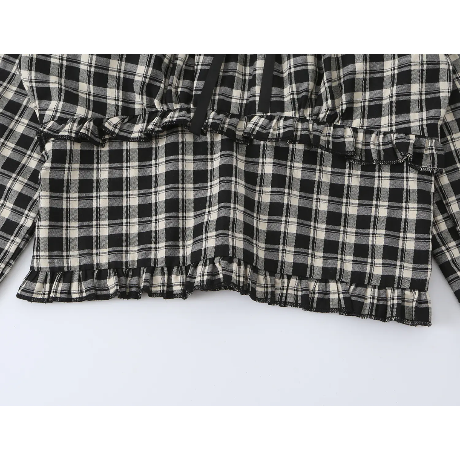 Wide shot tiered ruffle waist panel on black off-white check long sleeve crop top, double frill layered transition, soft plaid woven fabric texture