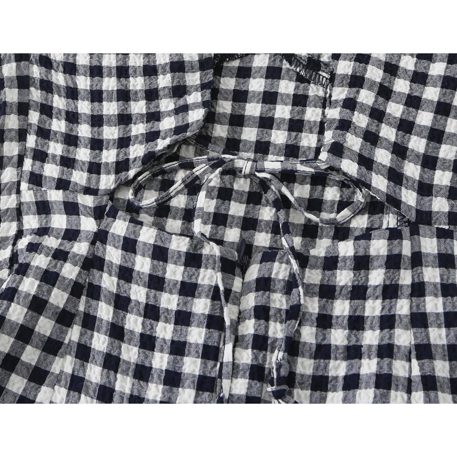Back waist hollow cutout fabric tie close-up, matching gingham tie string, layered back panel stitching, crinkle fabric texture