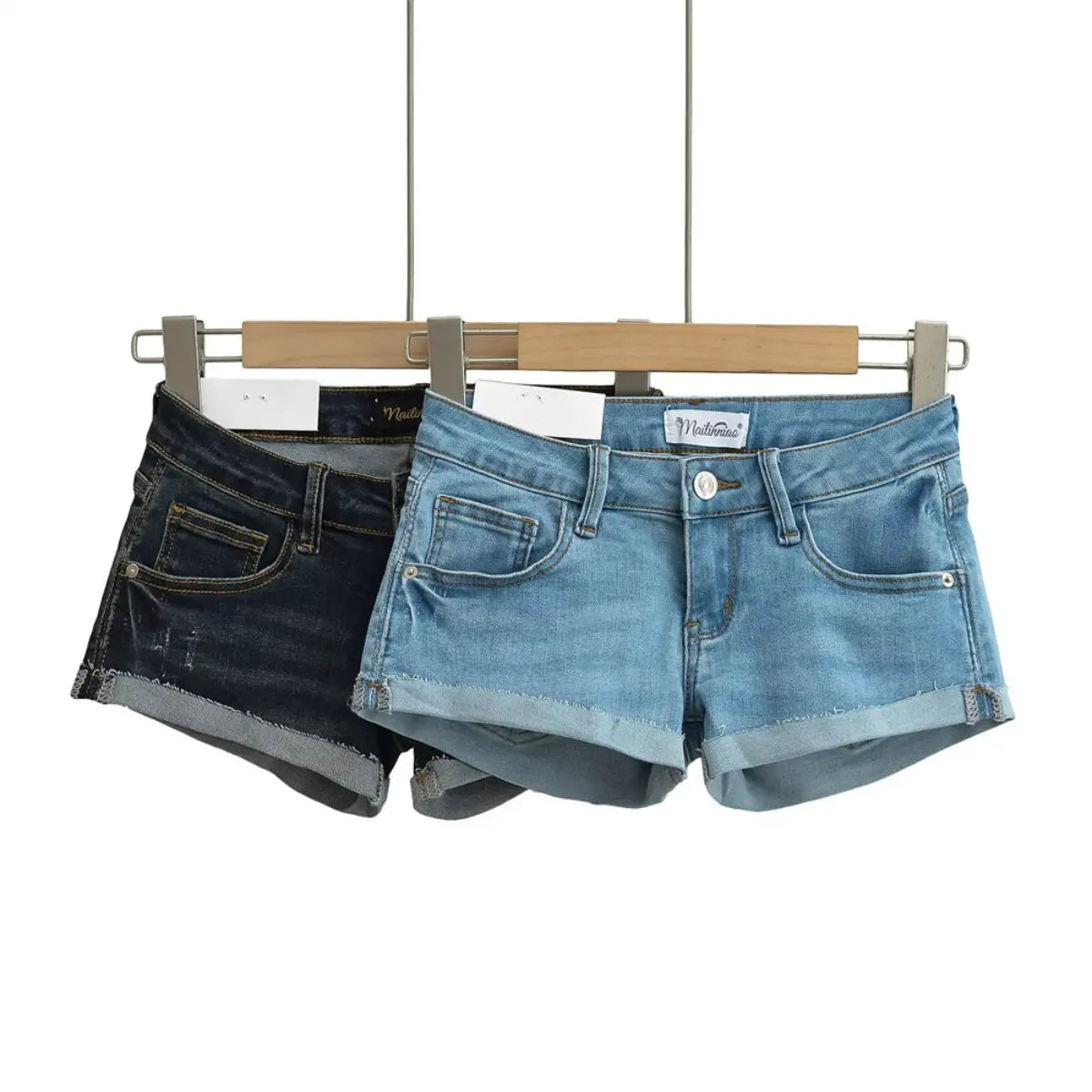 Light blue and dark wash low-rise denim shorts hanging on a wooden hanger.