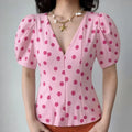 Front lifestyle model shot deep v neck fitted peplum waist polka dot blouse, retro bubble short sleeves