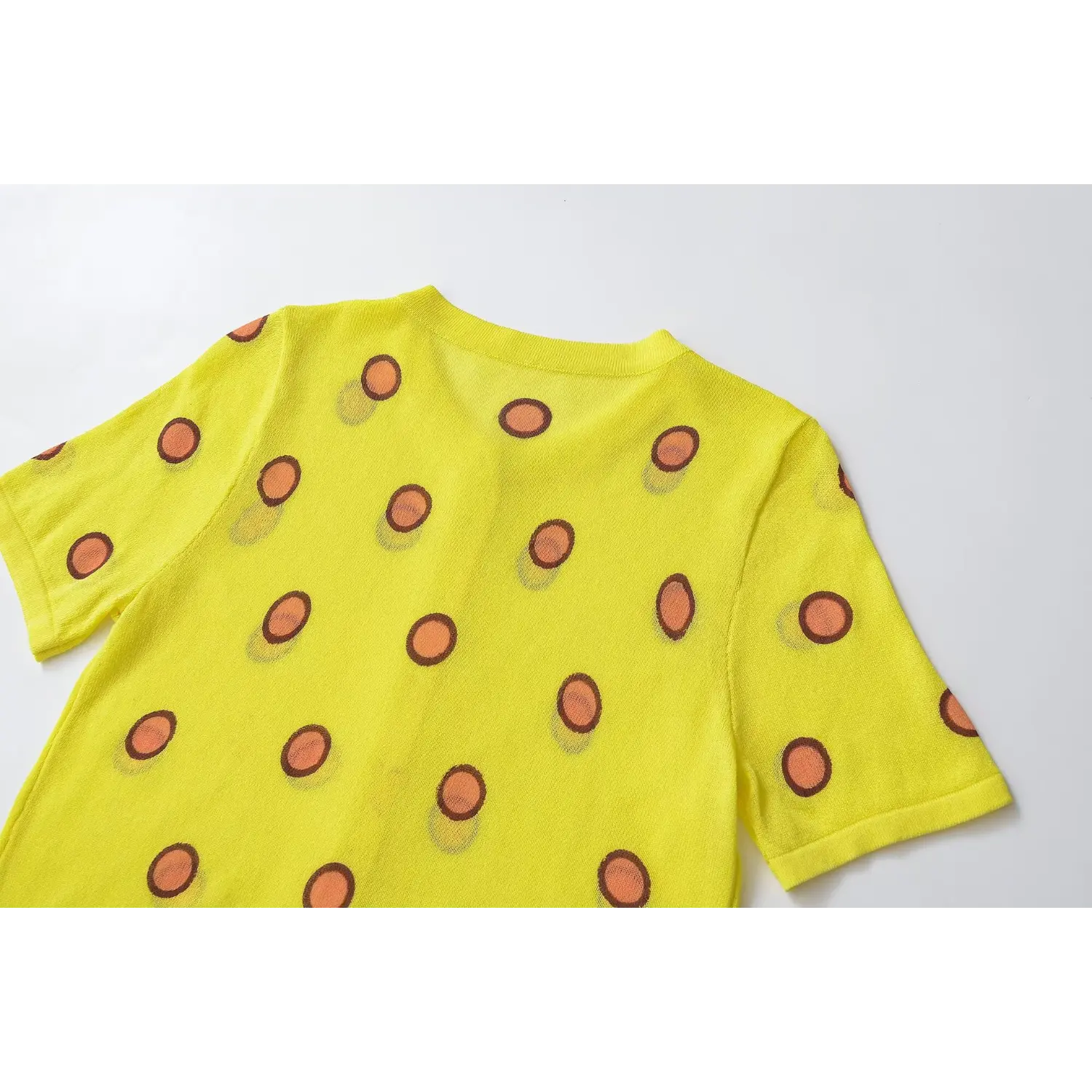 Back shoulder close-up, fine semi-sheer knit weave, polka dot layout, ribbed neckline stitching