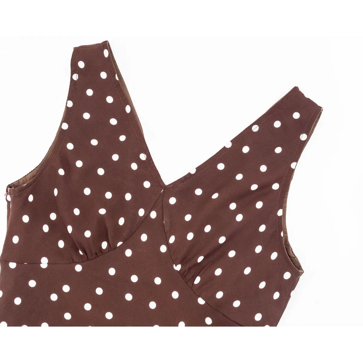 Close-up of the V-neck back on a brown and white polka dot dress, showing the double-stitched edges and gathered bust seams.