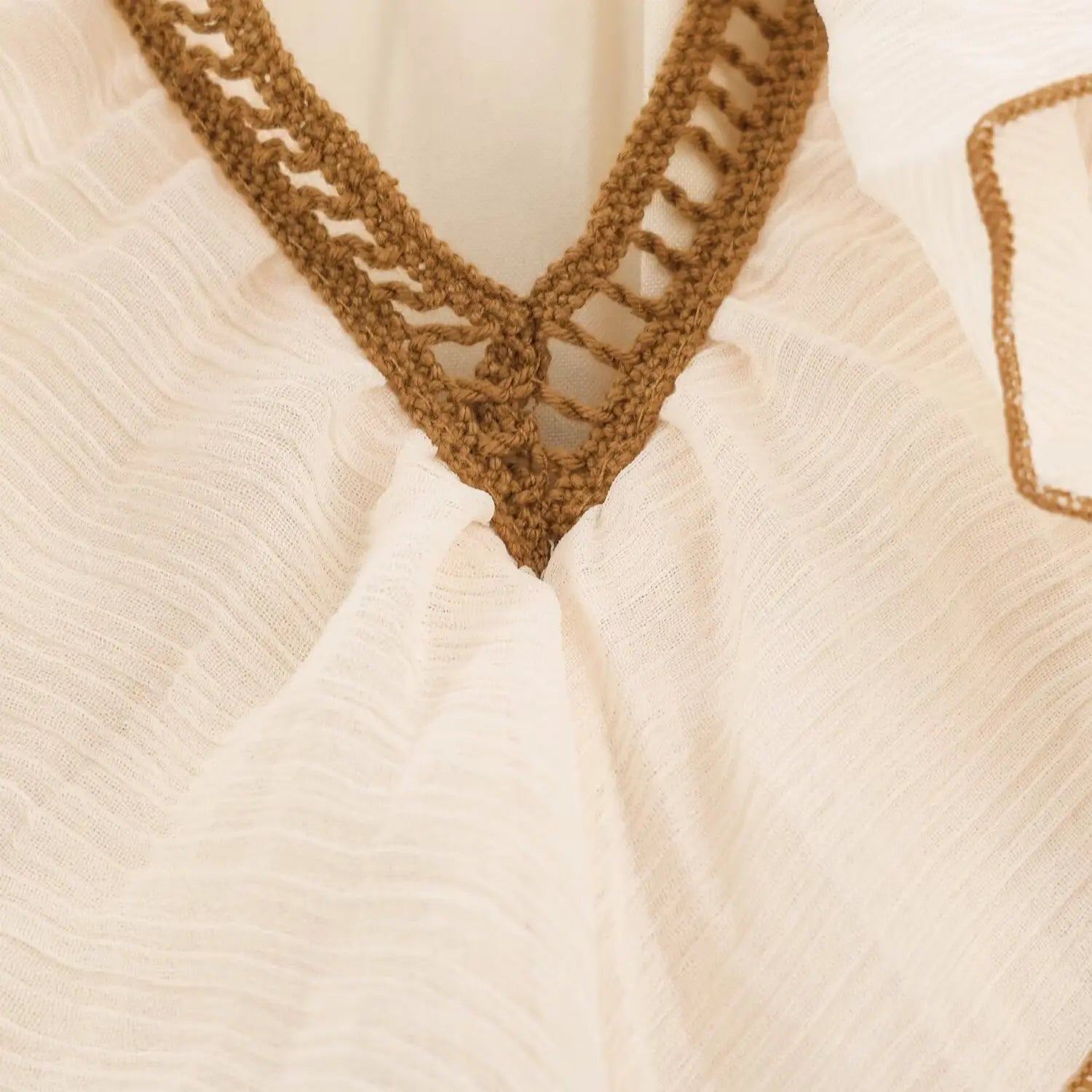 Macro shot brown hollow crochet lace trim on v-neckline beige boho dress