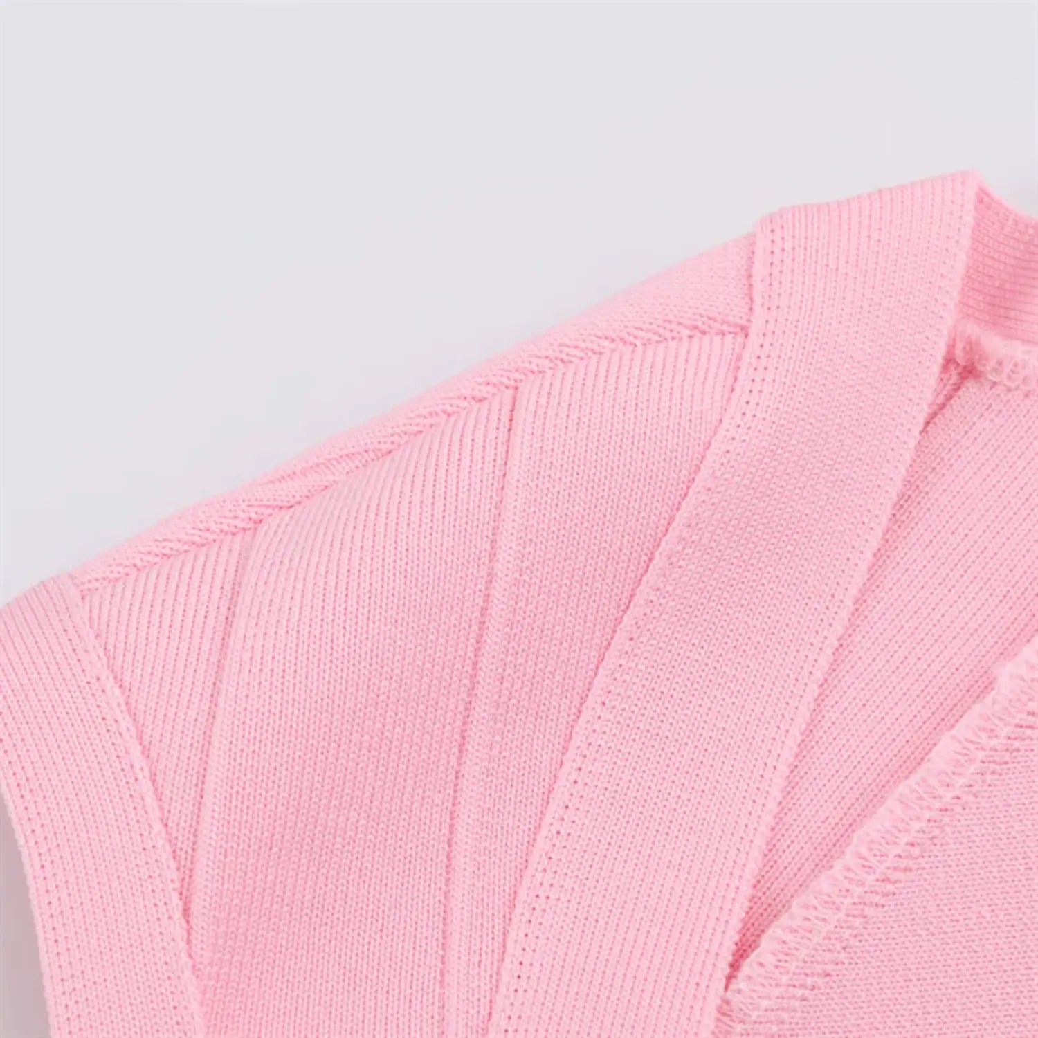 Extreme close-up of neck bandage strips, tightly woven stretch knit, parallel horizontal segmented seams, soft blush pink luster