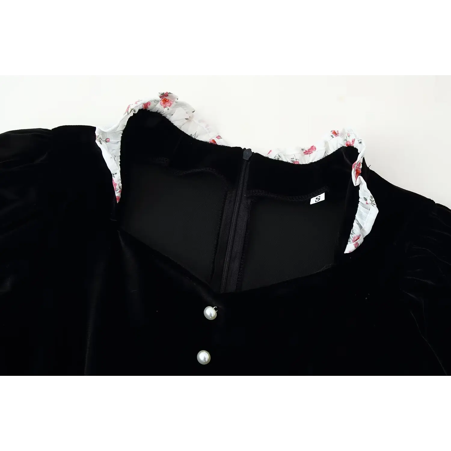 Close‑up of dress floral ruffle collar and back zipper, black velvet fabric, size tag detail