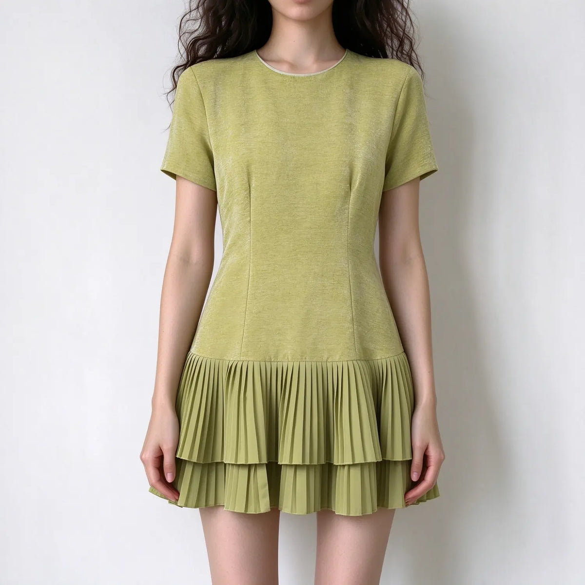 Model wearing olive green velvet pleated ruffle hem mini dress, front view