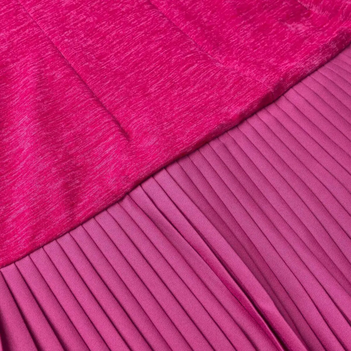 Close-up of fuchsia bodice and pleated skirt seam