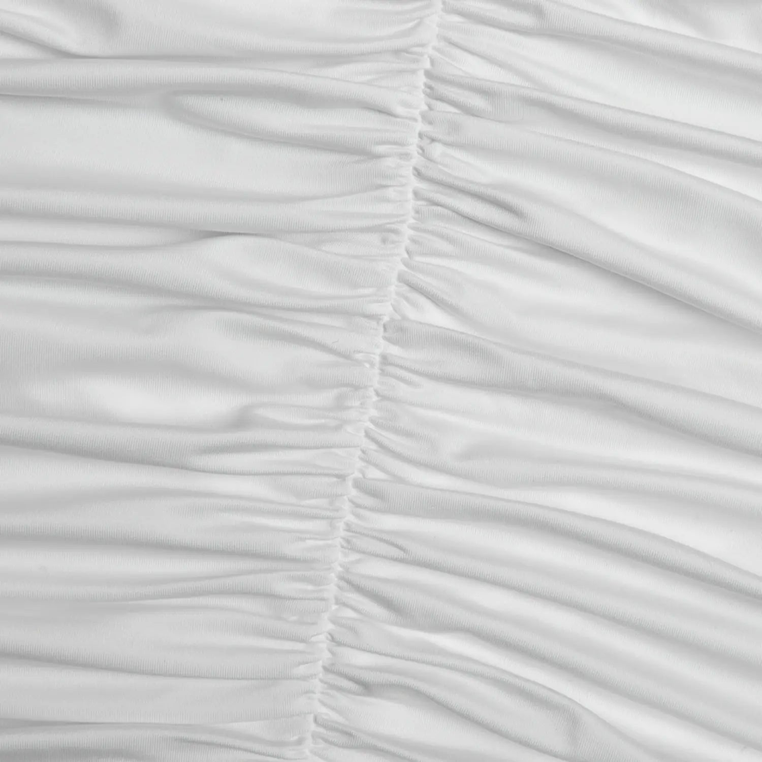 Macro shot vertical gathered ruched fabric seam on back of white mini dress