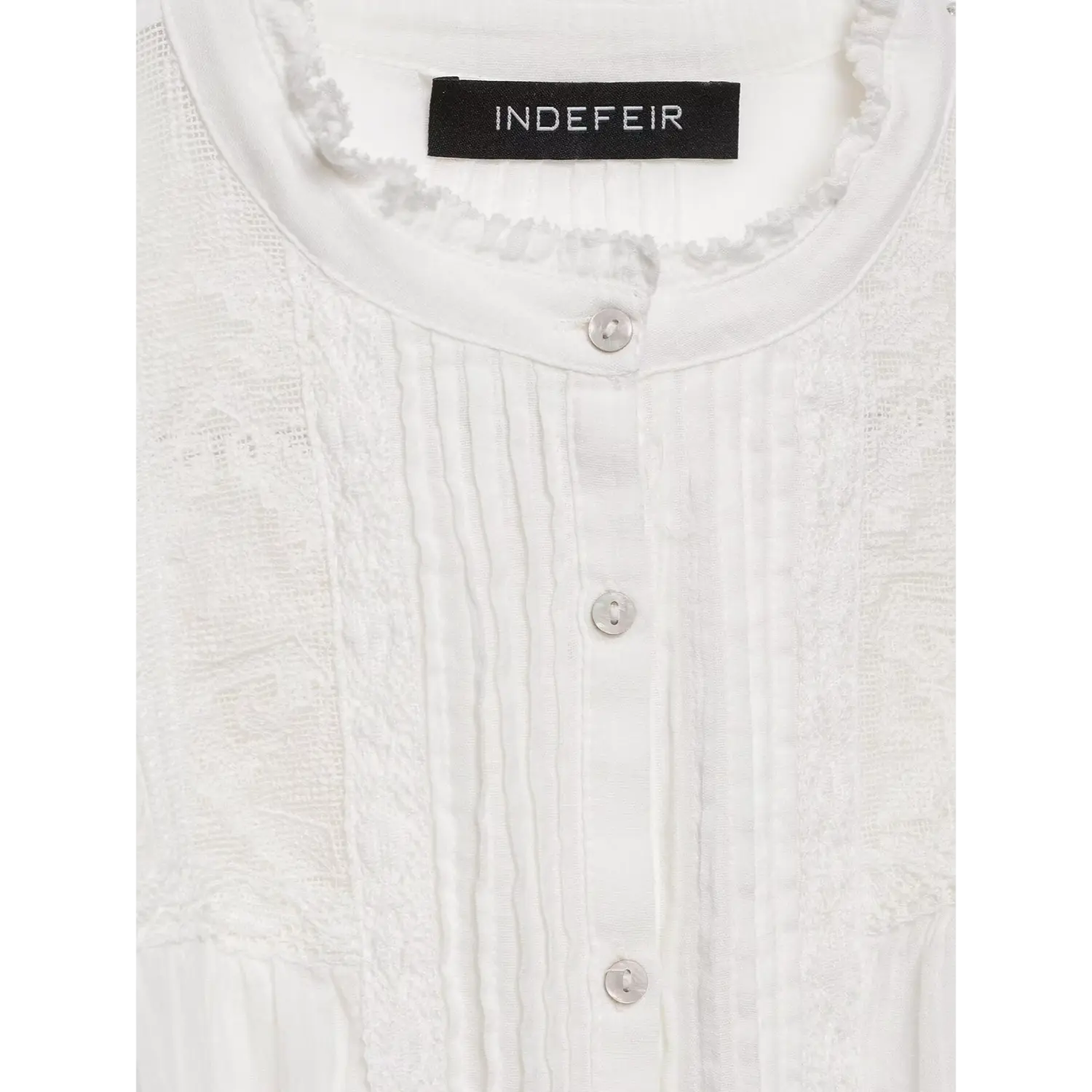 Macro close-up of natural shell buttons, vertical pintuck pleats and lace trim along front placket