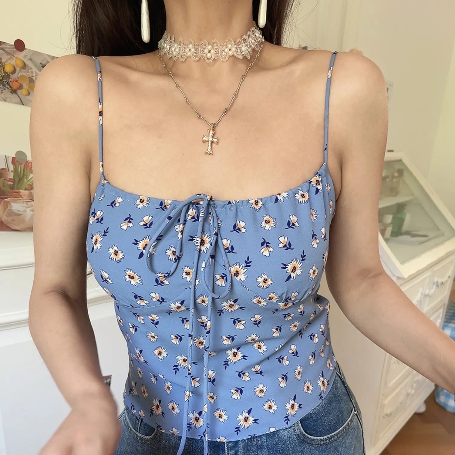 Vintage haze blue daisy floral cami crop top, long adjustable front tie elastic neckline, low angle full indoor model wearing shot