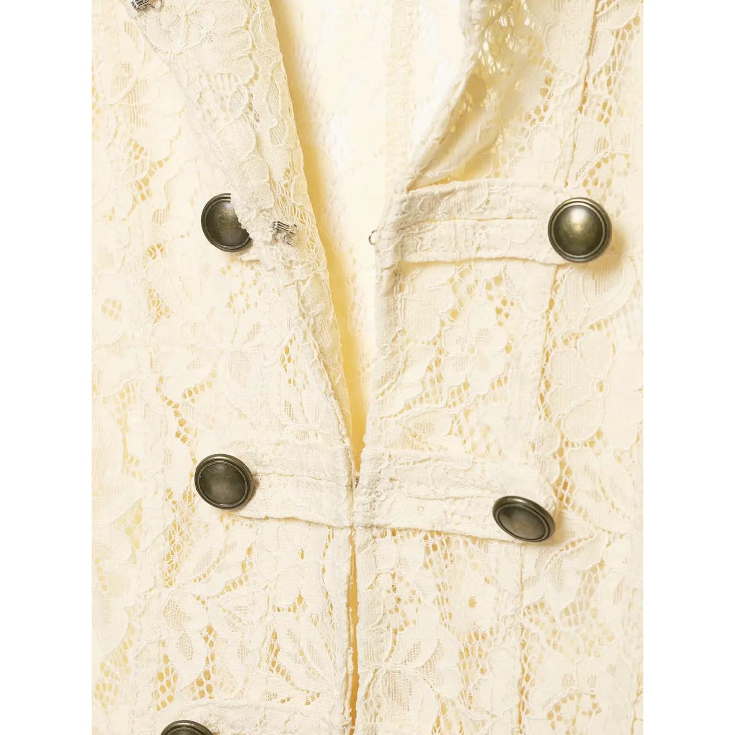Close up view of vintage brass double buttons on ivory lace short jacket, hollow floral lace fabric