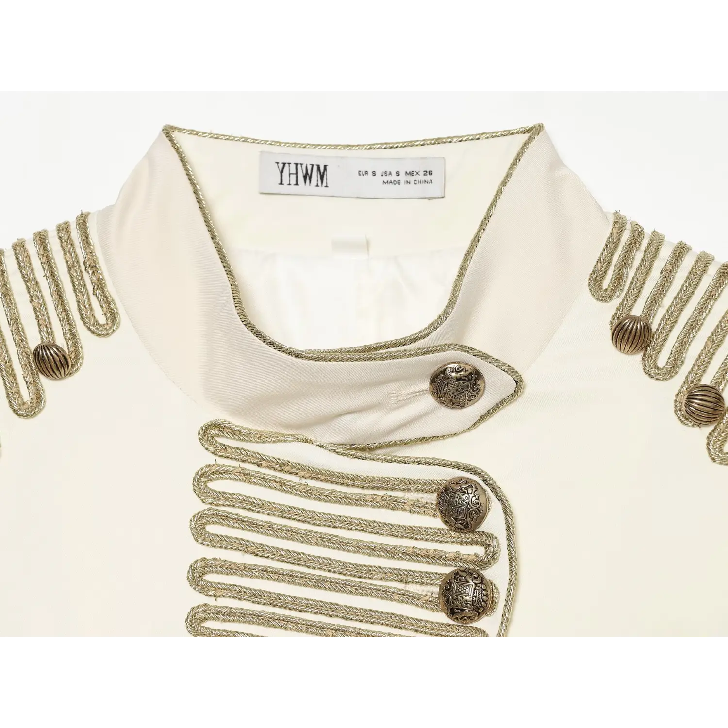 Macro shot vintage embossed brass buttons and gold braided trim on off-white tailored blazer collar