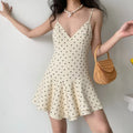Indoor lifestyle photo of retro polka dot mini dress styled with rattan woven handbag, casual summer dating outfit.
