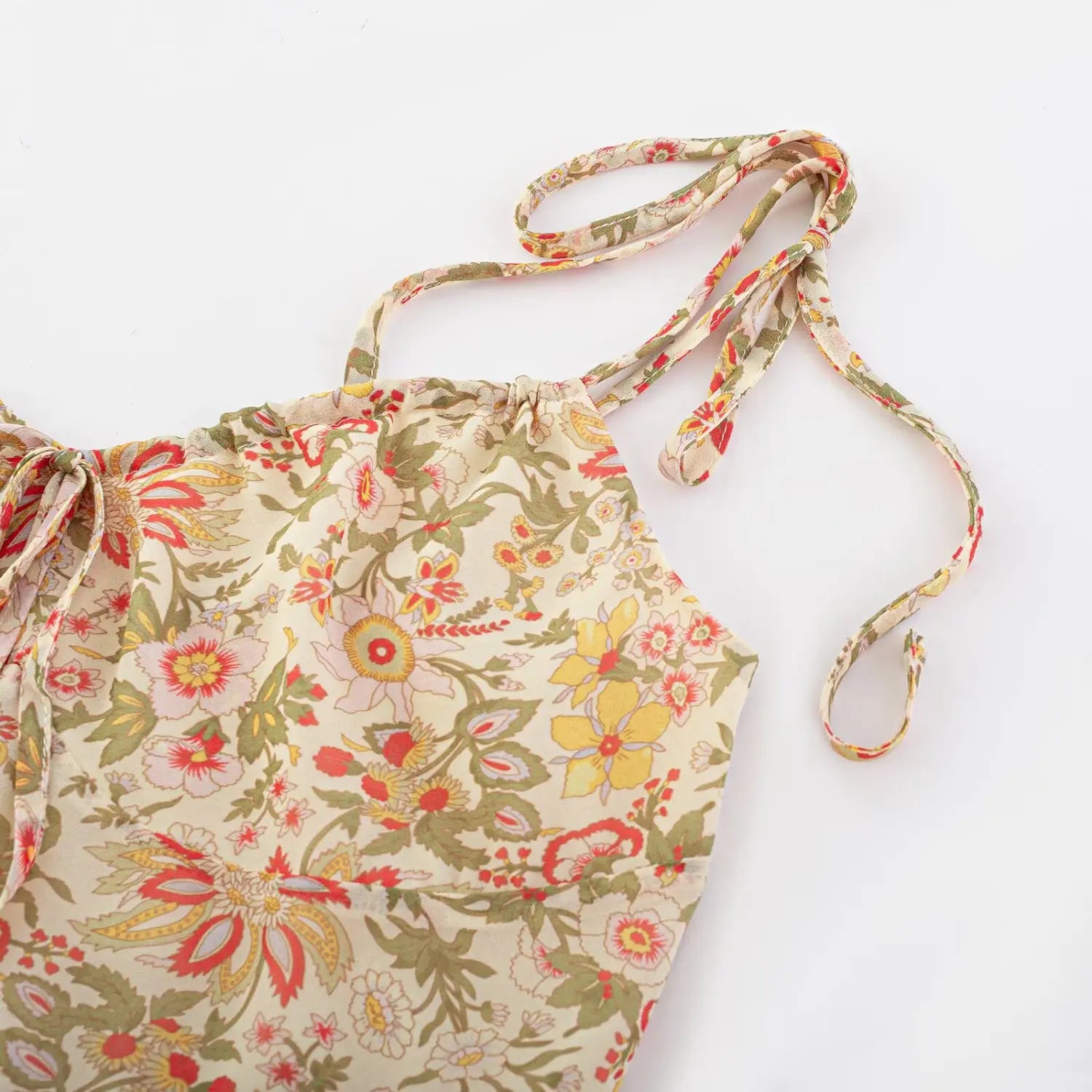 Close flat detail shot of matching printed chiffon tie shoulder straps for floral mini dress, long adjustable ribbon ends with finished narrow hem