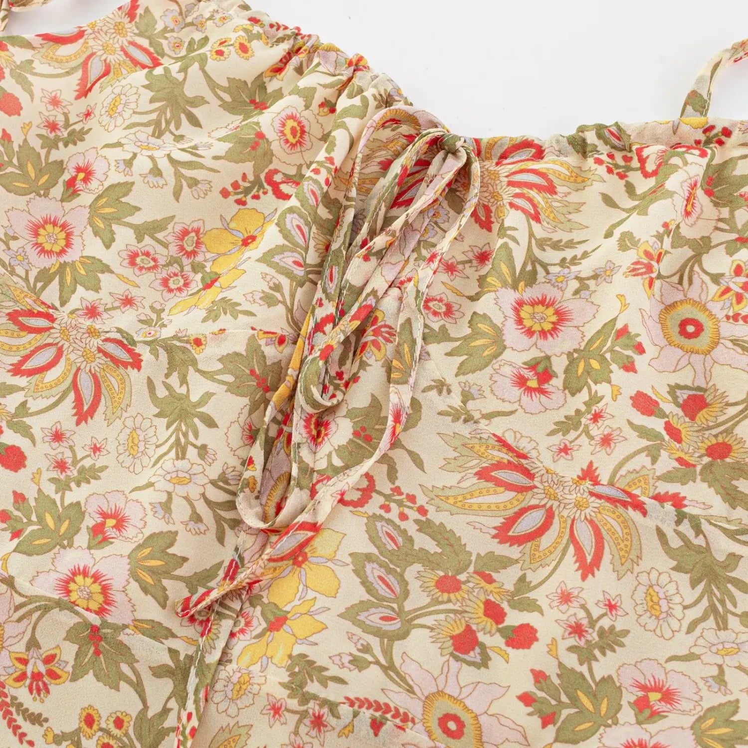 Macro close-up of front bust drawstring tie on retro floral chiffon mini dress, gathered ruched fabric with matching printed self-fabric ribbon bow