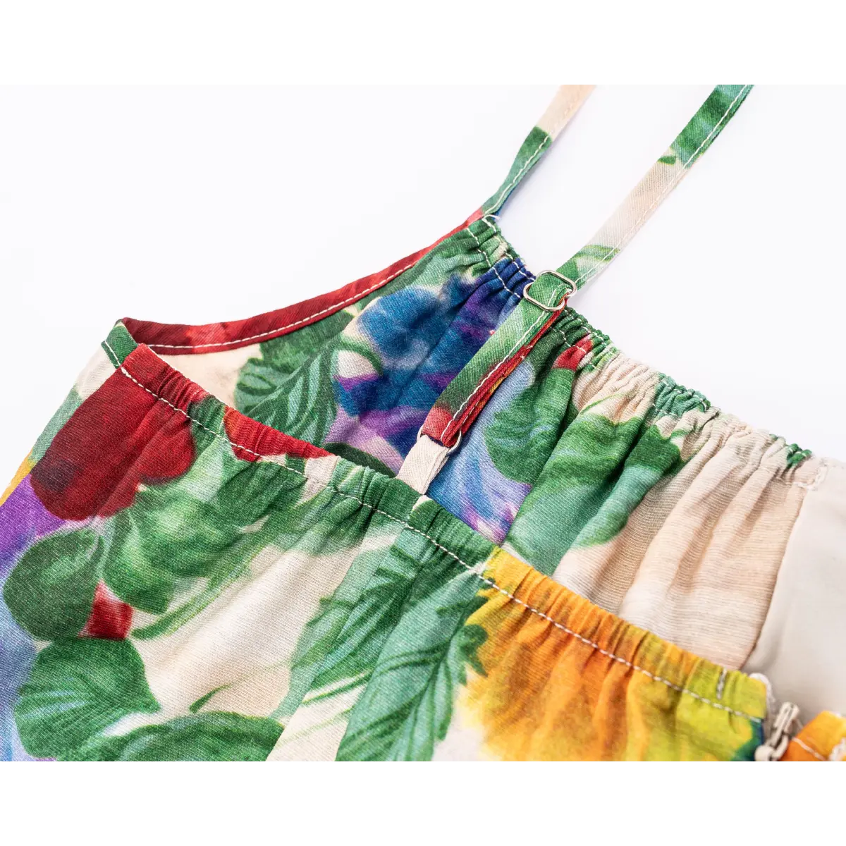 Close-up of bust part with shirred elastic top and adjustable metal slider spaghetti straps, colorful vintage floral print.