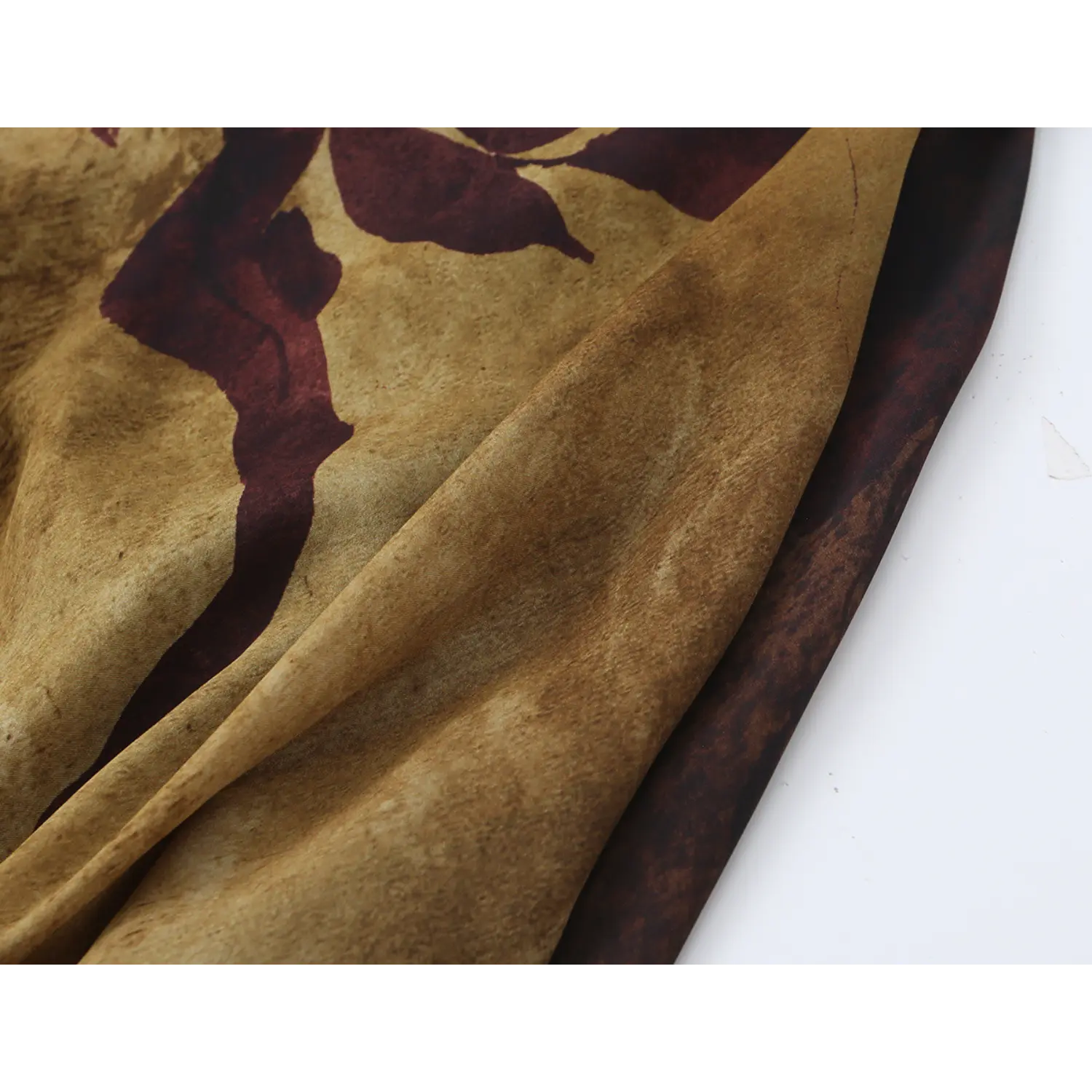 Close‑up showing drape and soft folds of sepia floral printed lightweight dress fabric