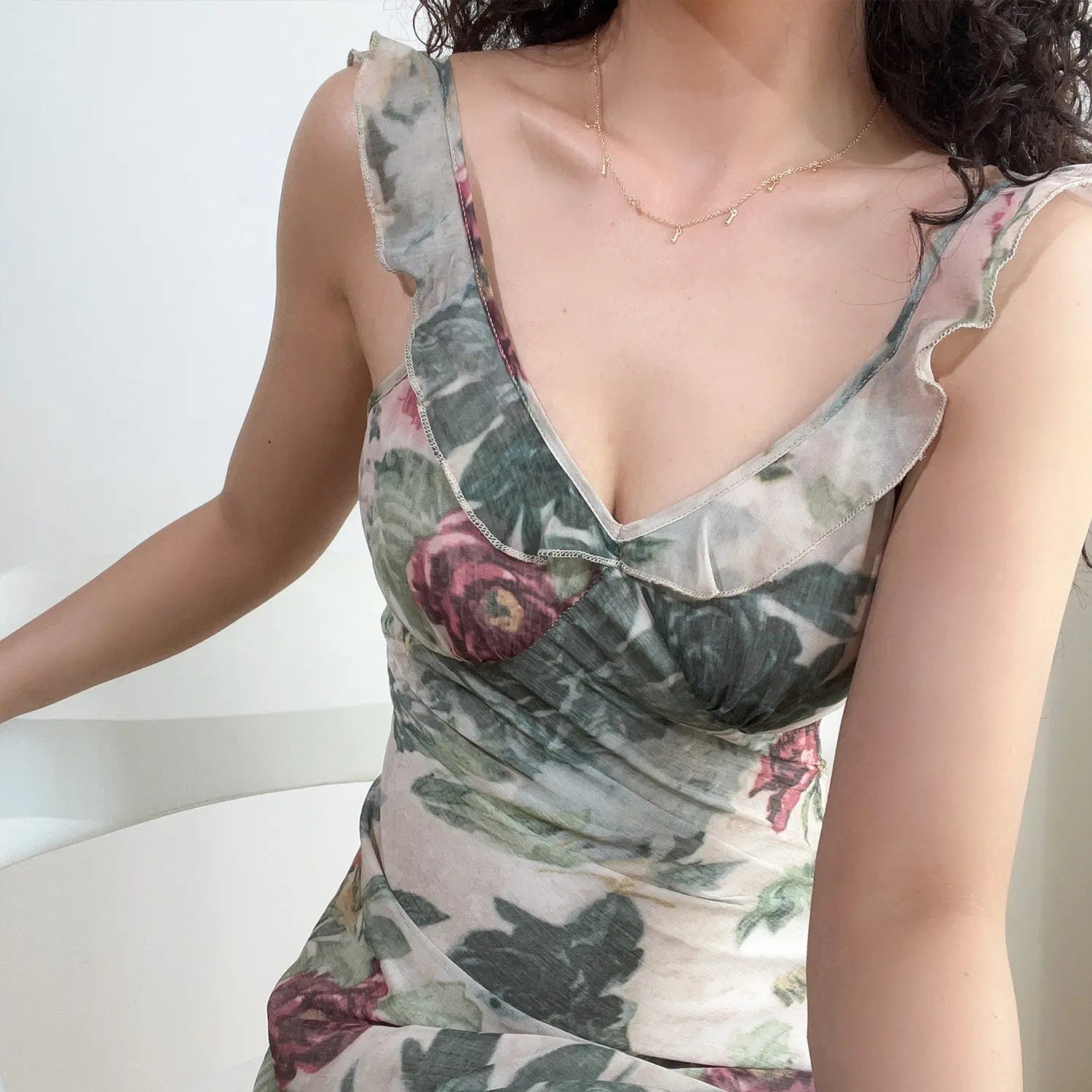 Model upper body close‑up showing v‑neck ruffle strap and bust stitching of vintage floral mini dress