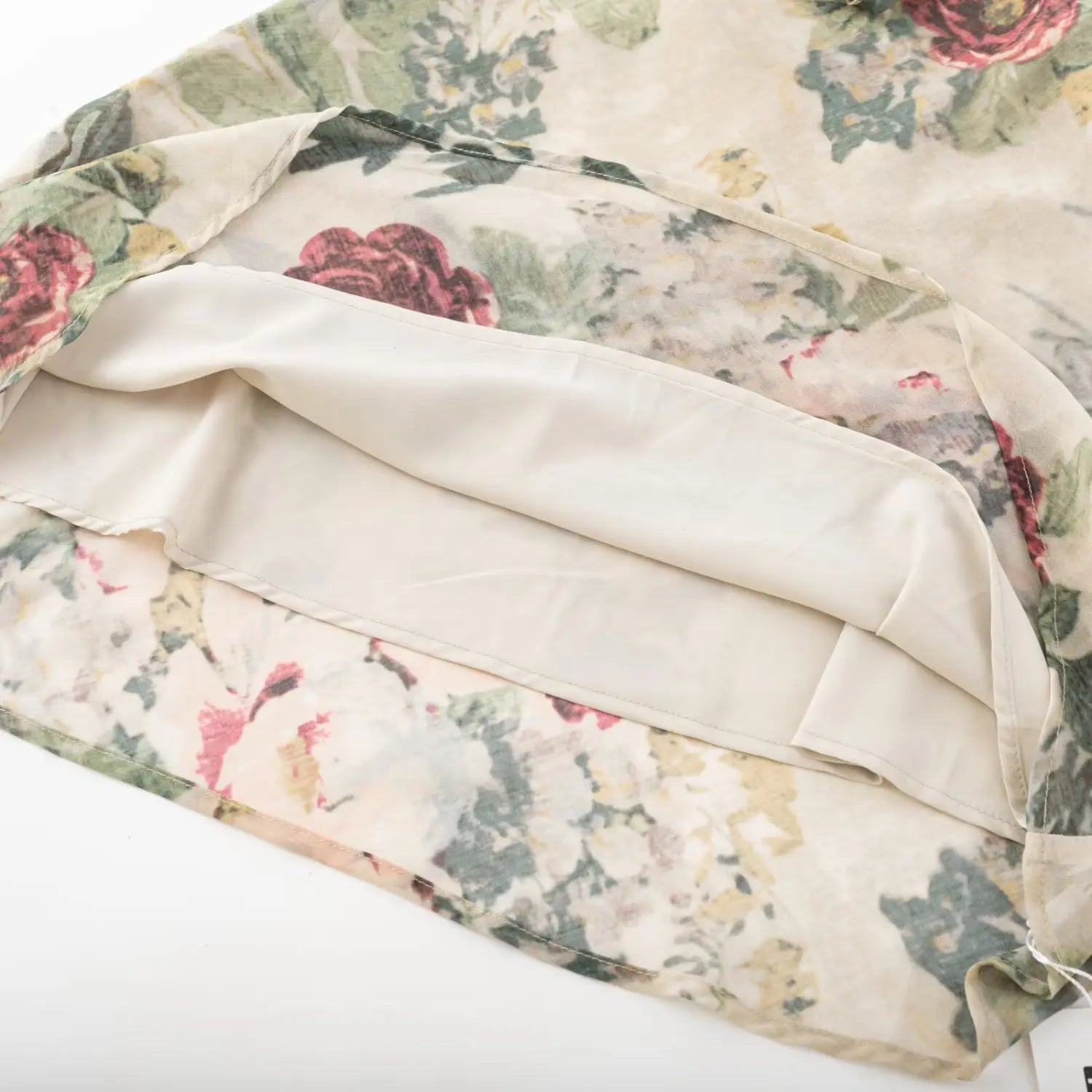 Close‑up of skirt hem showing inner lining layer of vintage floral ruffle strap mini dress
