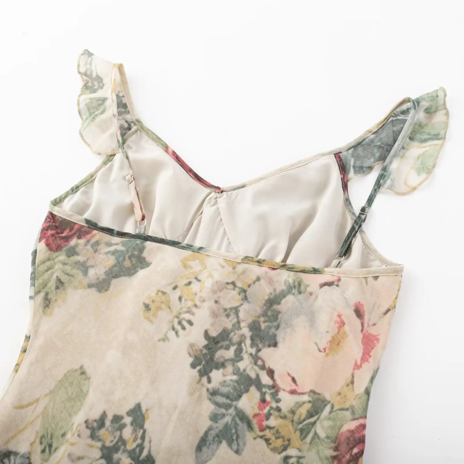 Close‑up shot inner back of vintage floral mini dress, adjustable ruffle shoulder straps and lining stitching detail