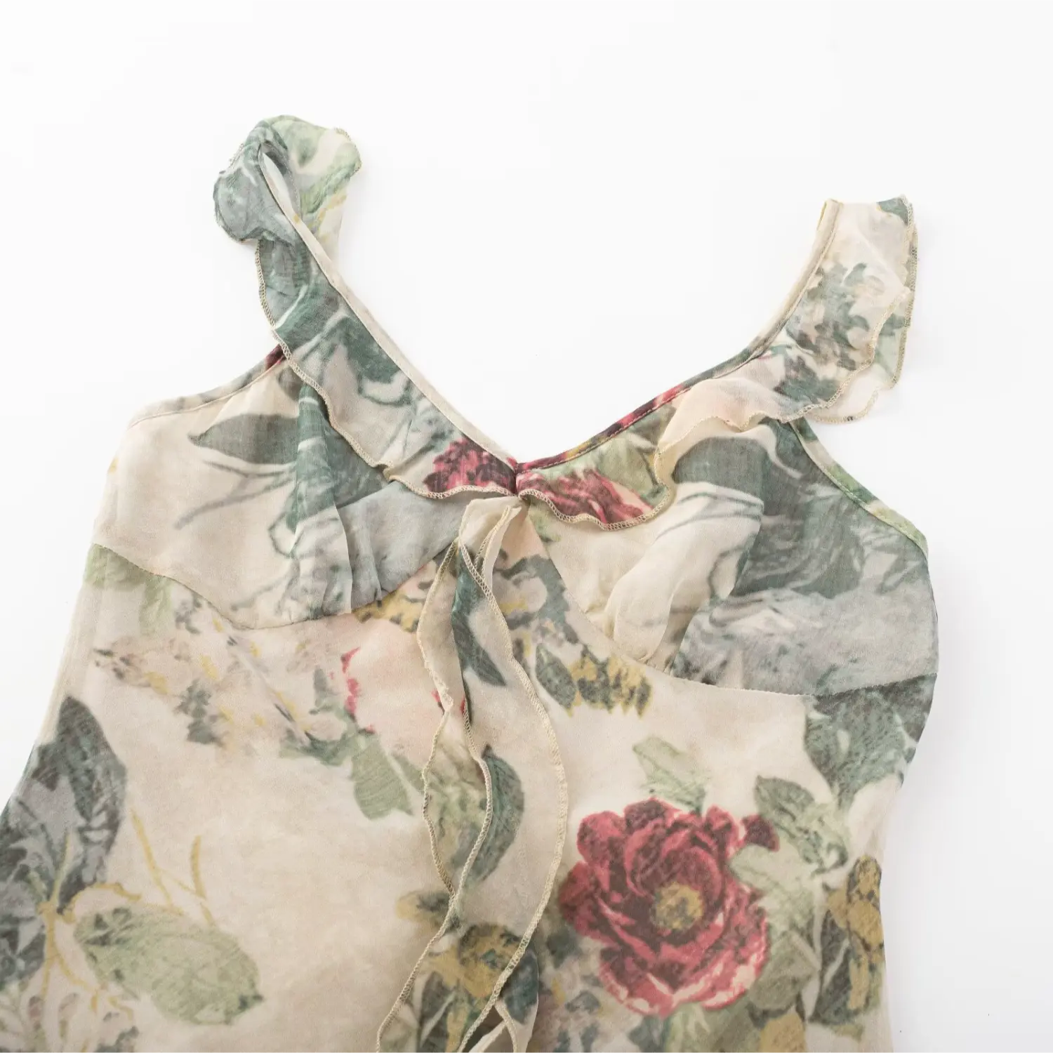 Flat lay close‑up of v‑neck bust area, ruffle trim and front tie detail on vintage floral mini dress
