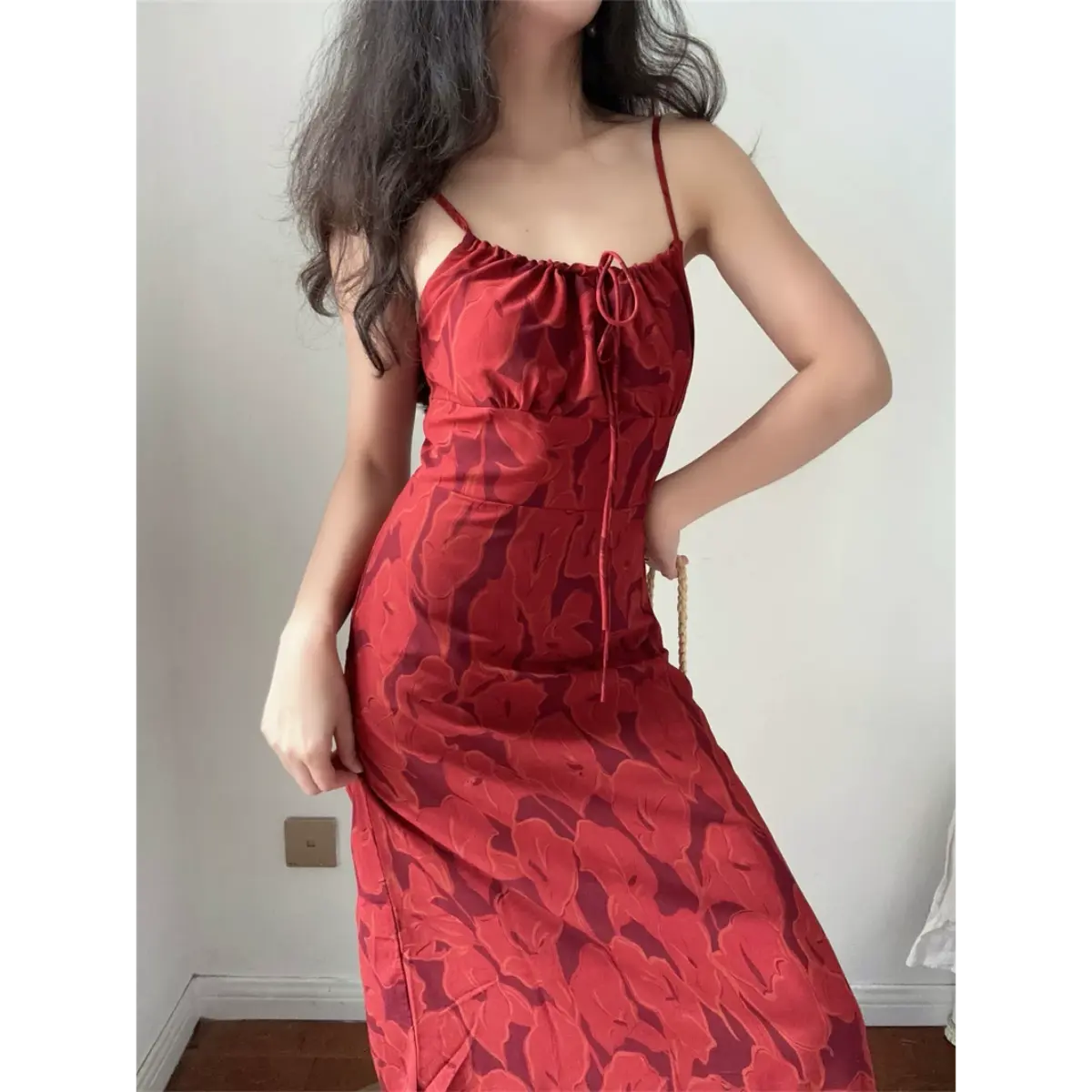 Standing indoor lifestyle picture of warm red abstract floral midi dress, waist tailored slim cut and flowy skirt for romantic date style.
