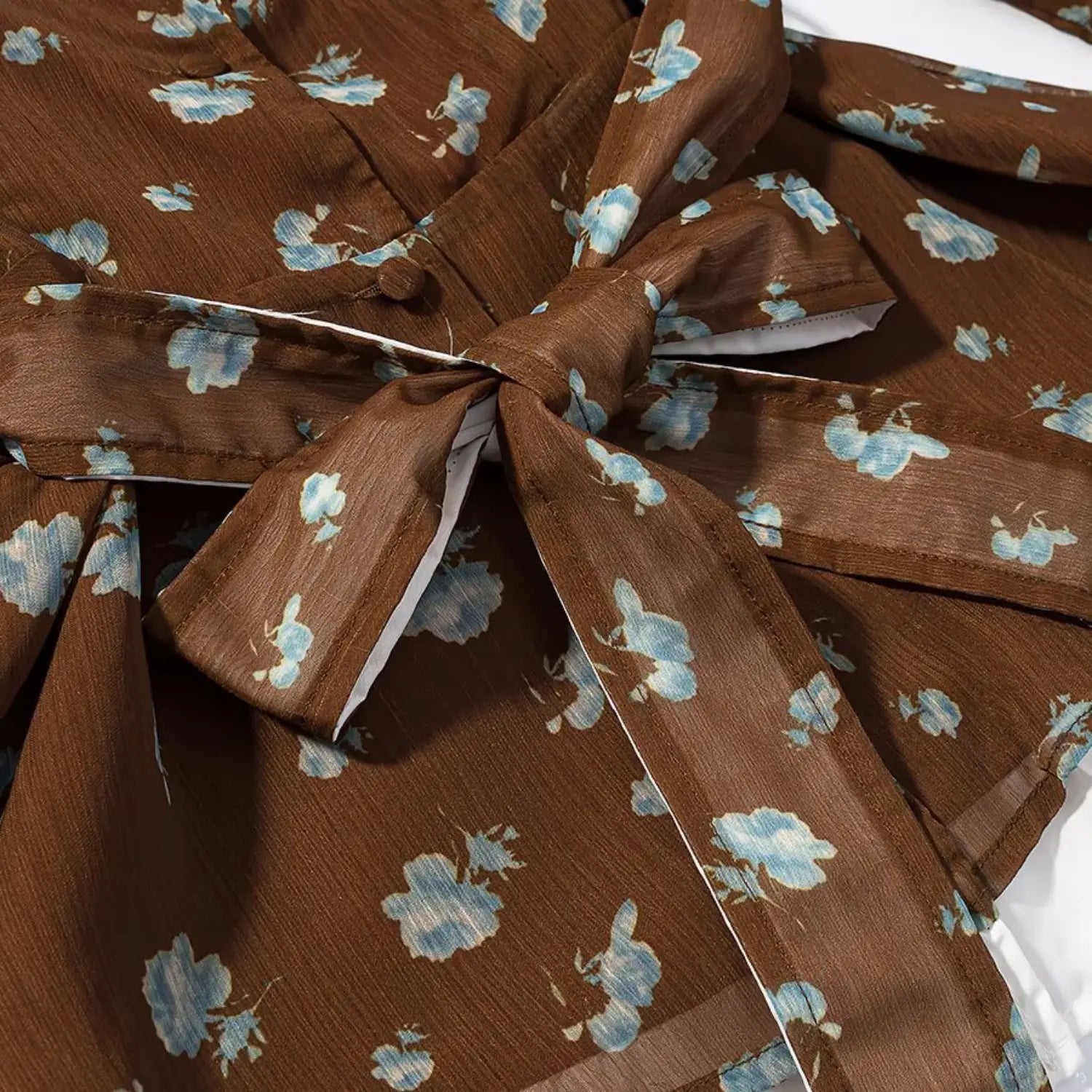 Matching floral fabric waist tie bow close-up, same coffee blue blossom printed chiffon