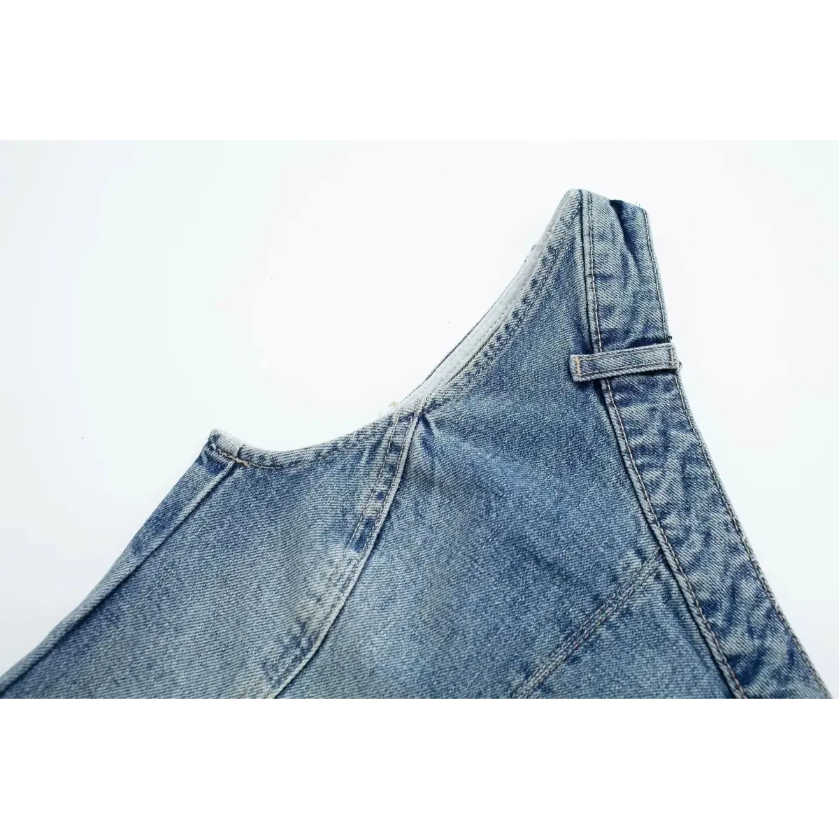 Side view detail of the structured seams and cut-out on the washed denim strapless top.
