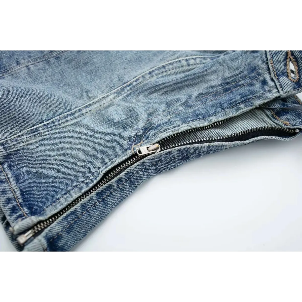 Close-up of the side zipper closure on the washed denim strapless bustier top.
