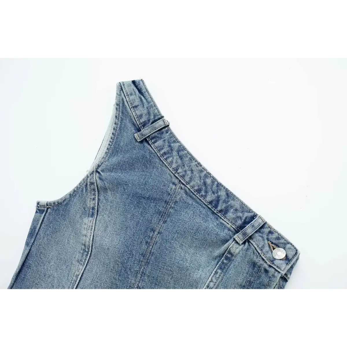 Close-up of the waistband and button closure on the washed denim strapless bustier top.