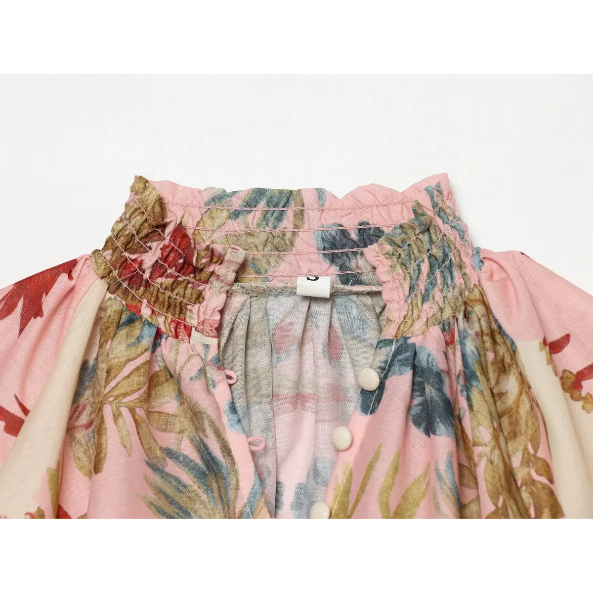 Close-up of smocked ruffled high neck and back buttons