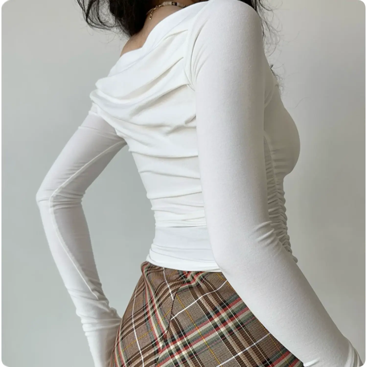 Back three‑quarter view white asymmetry off‑shoulder long sleeve crop top draped ruched back thumb hole fitted top