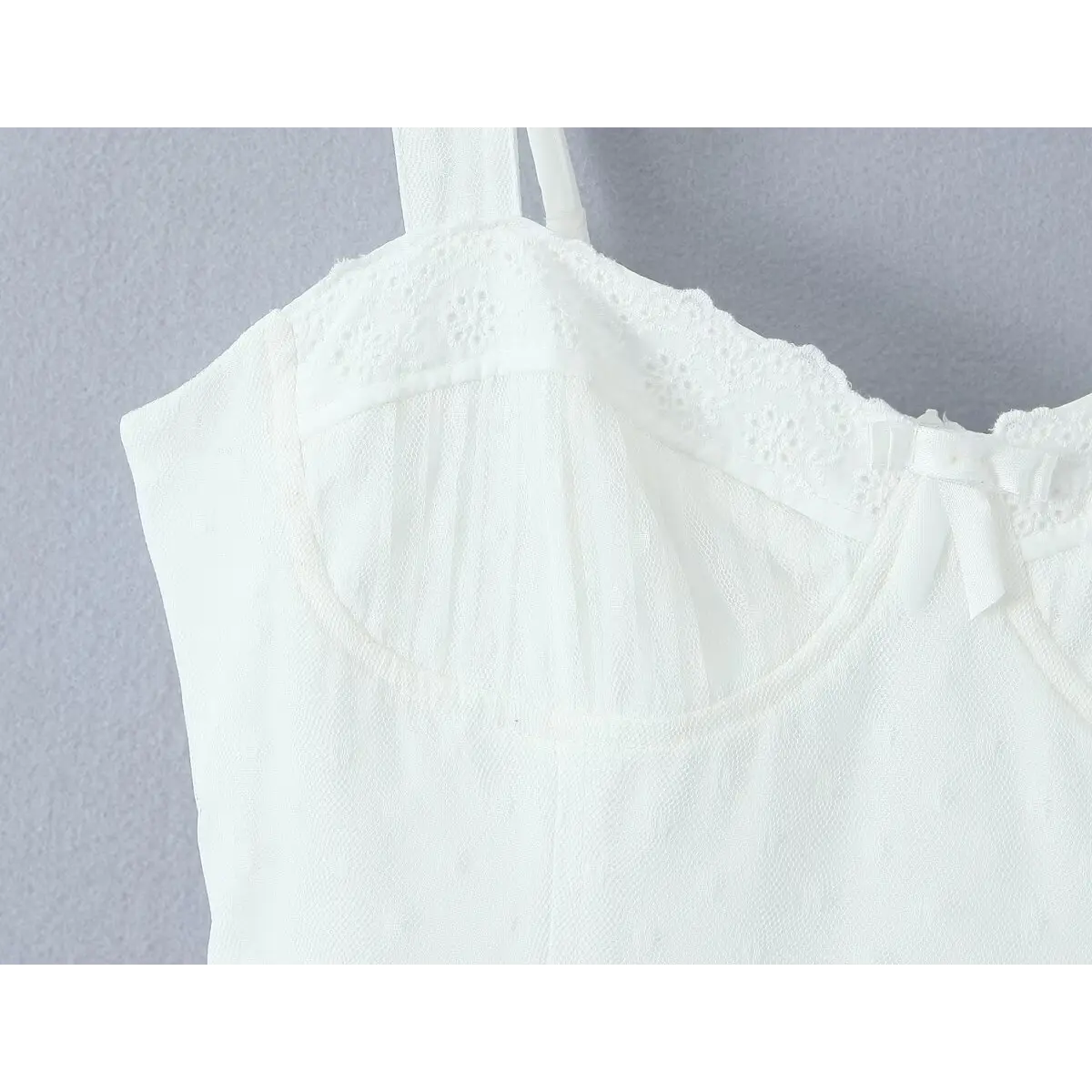 Close-up of the central fabric bow, eyelet lace trim, and boned bust cup detailing.