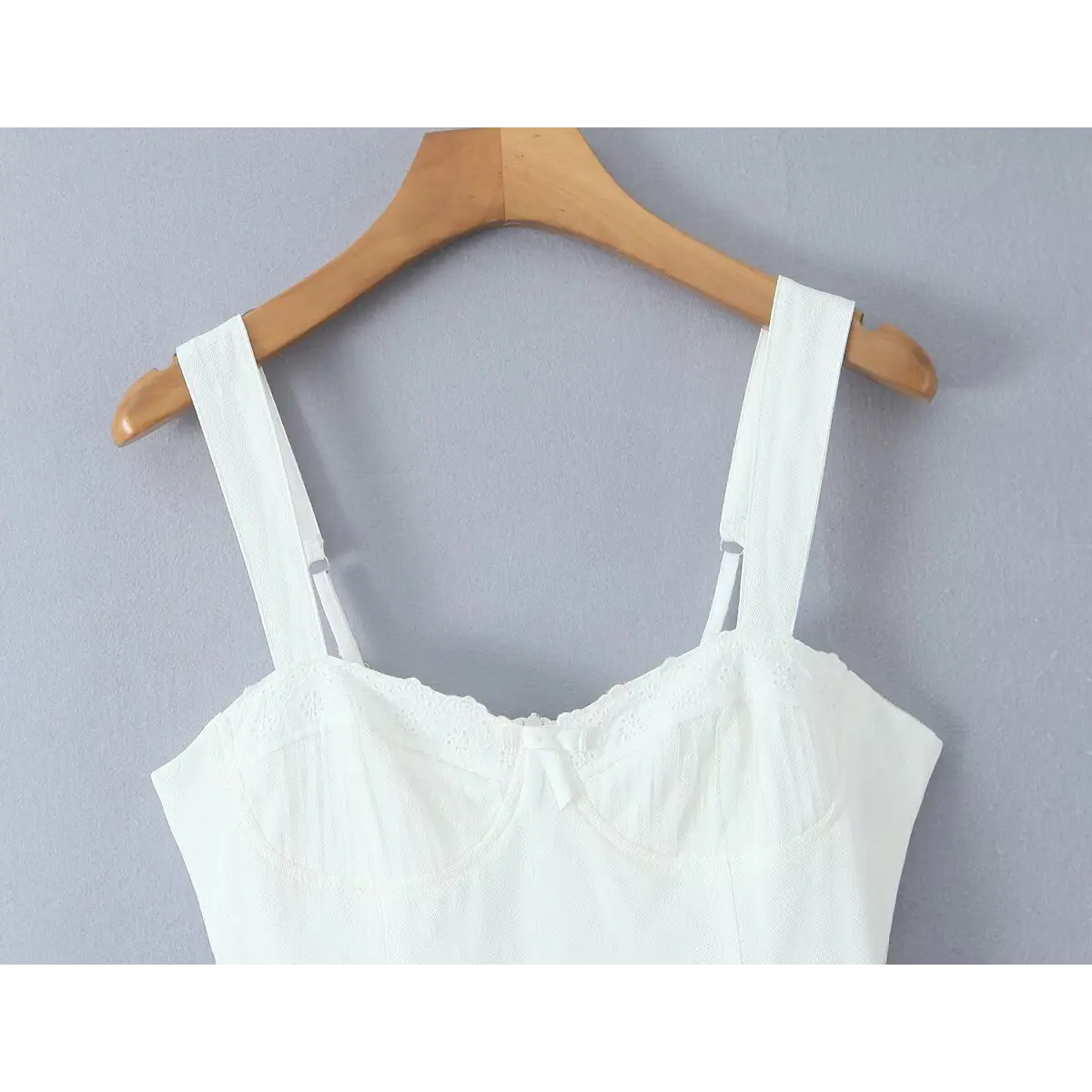 Close-up of sweetheart neckline with eyelet lace trim, central bow, and boned bust cups.