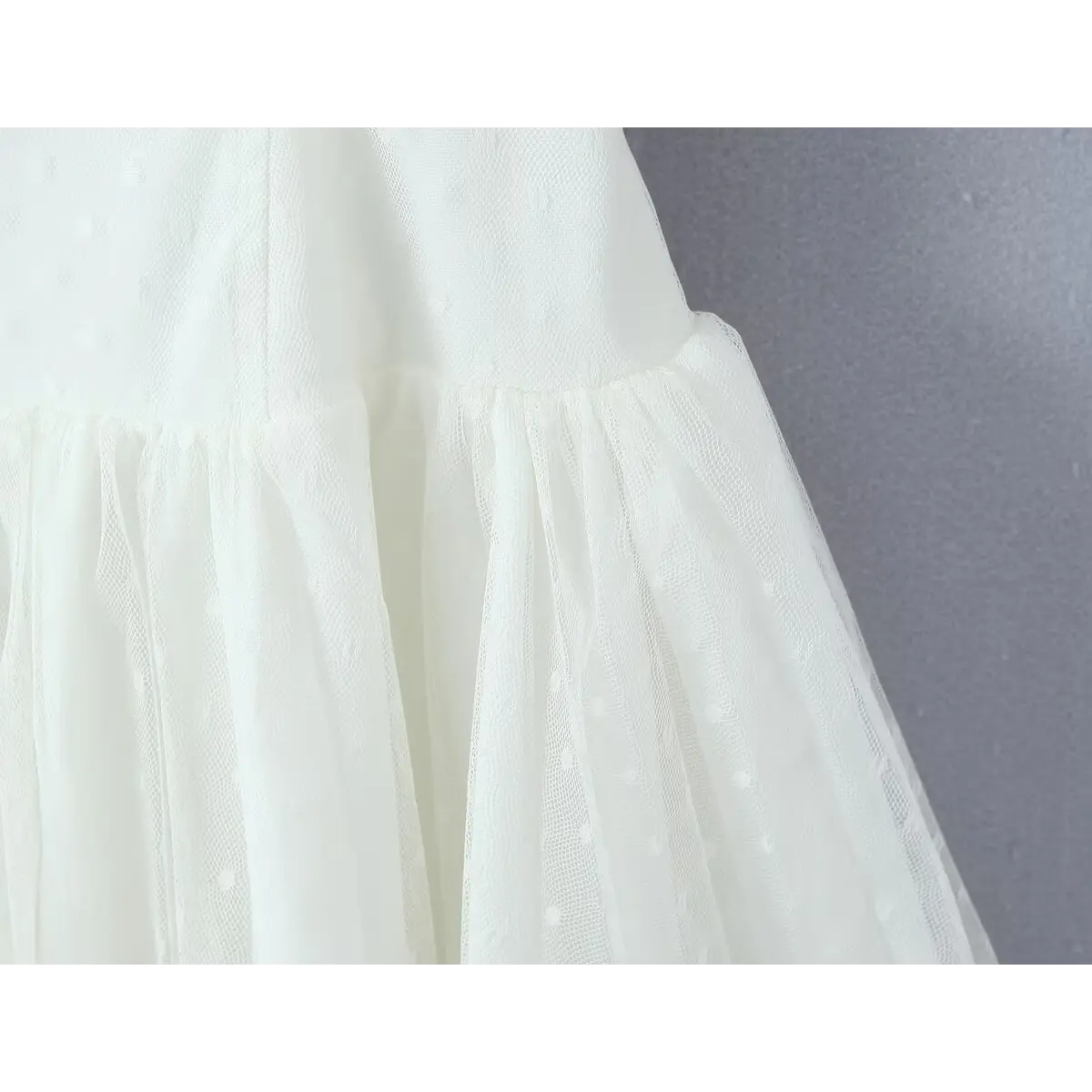 Close-up of the waist seam where the corset bodice transitions into the gathered tulle skirt.