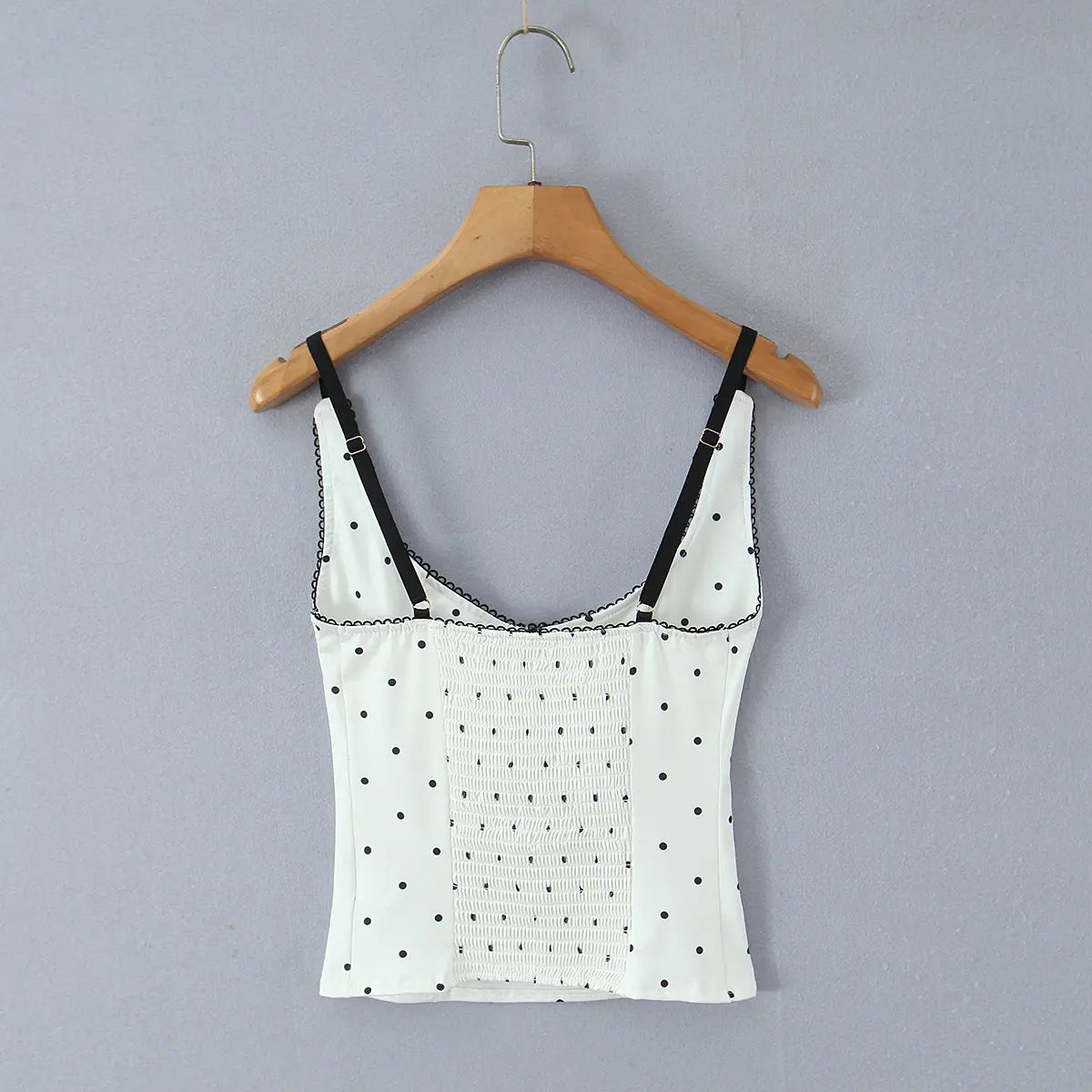 Full back view of the white cami top, featuring black polka dots, adjustable straps, lace trim, and smocked detailing.