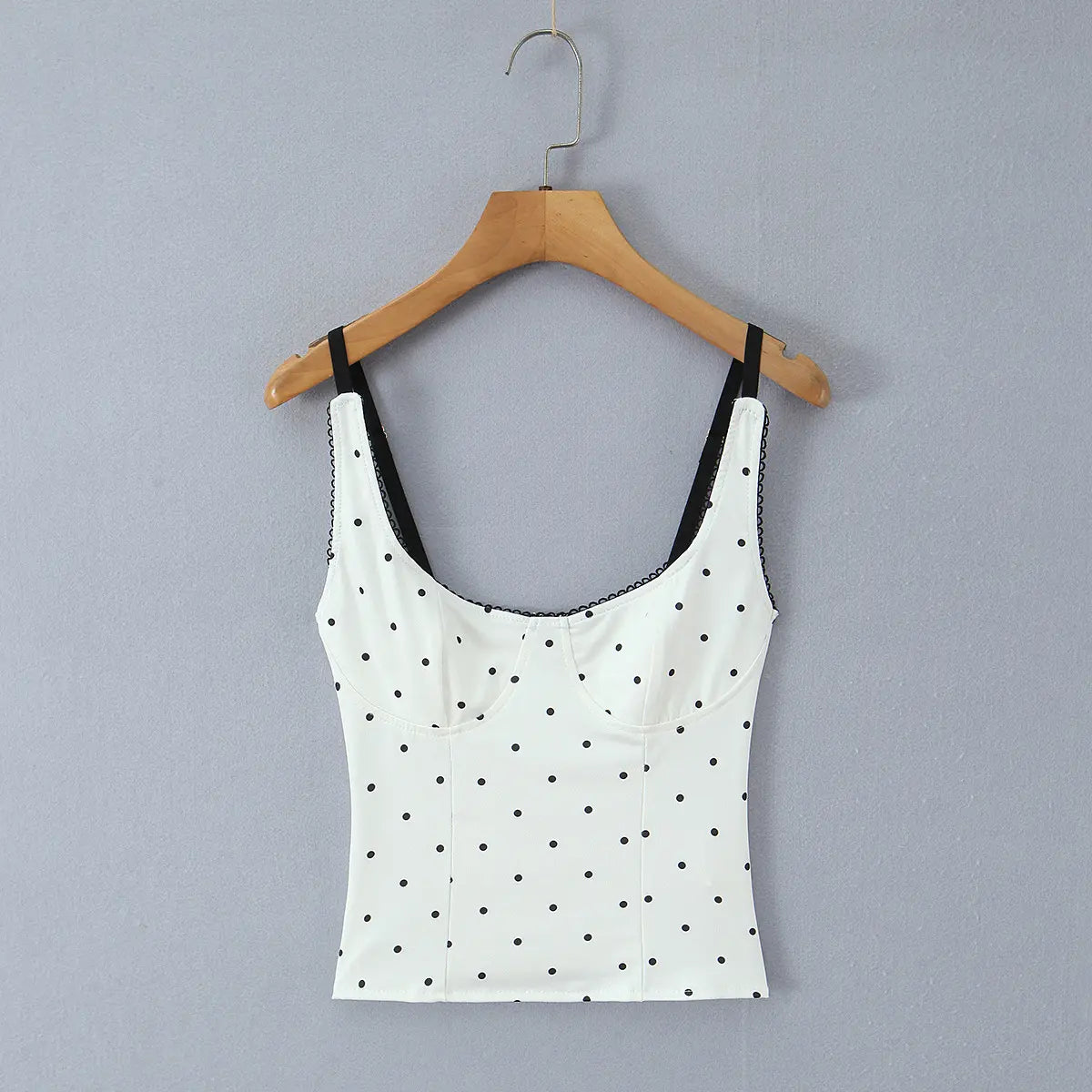 Full front view of the cami top, featuring a sweetheart neckline, bustier-style cups, and black polka dots.