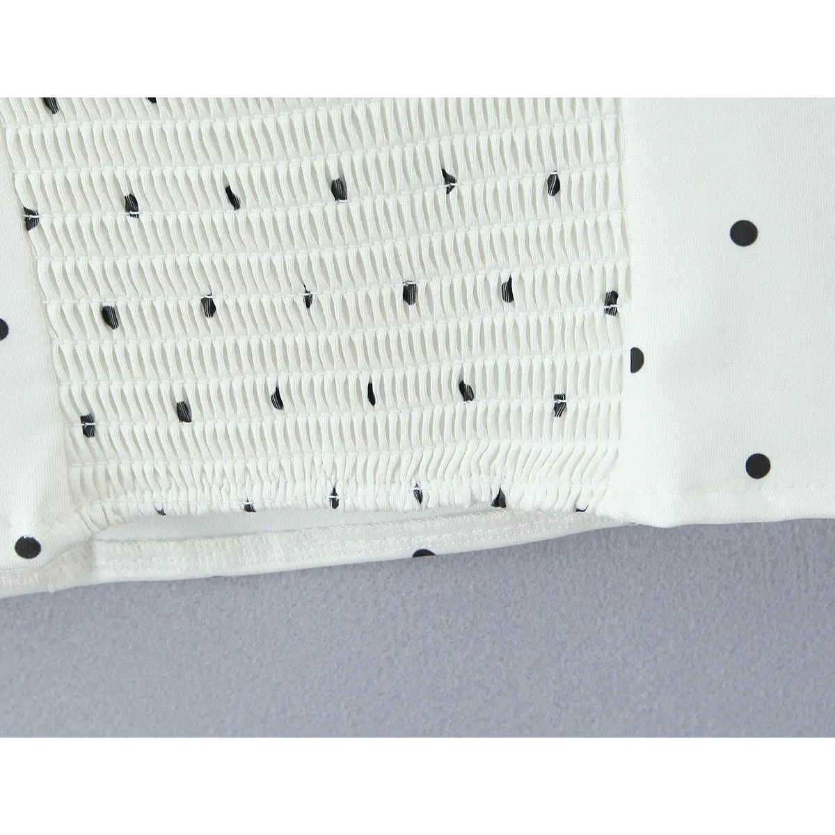 Close-up of the intricate stitching and texture of the smocked panel.