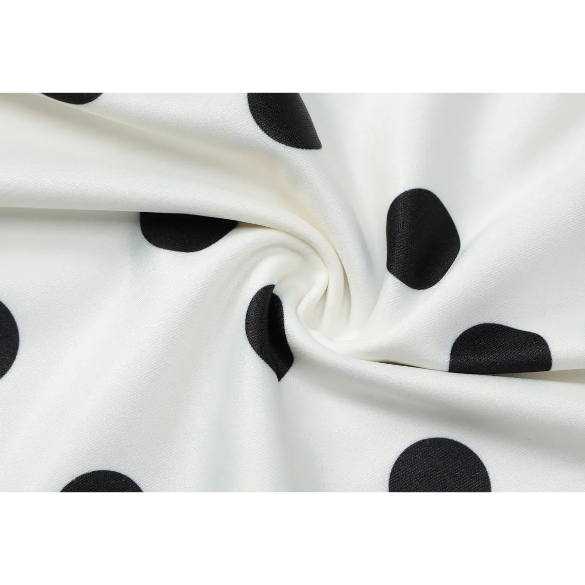 Close-up of the smooth, stretchy fabric texture and bold black polka dot print.