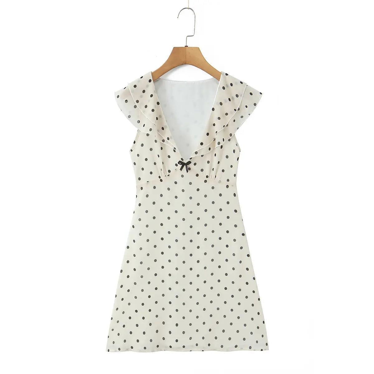 Full front view of the white polka dot dress with V-neck, ruffled trim, and waist bow.