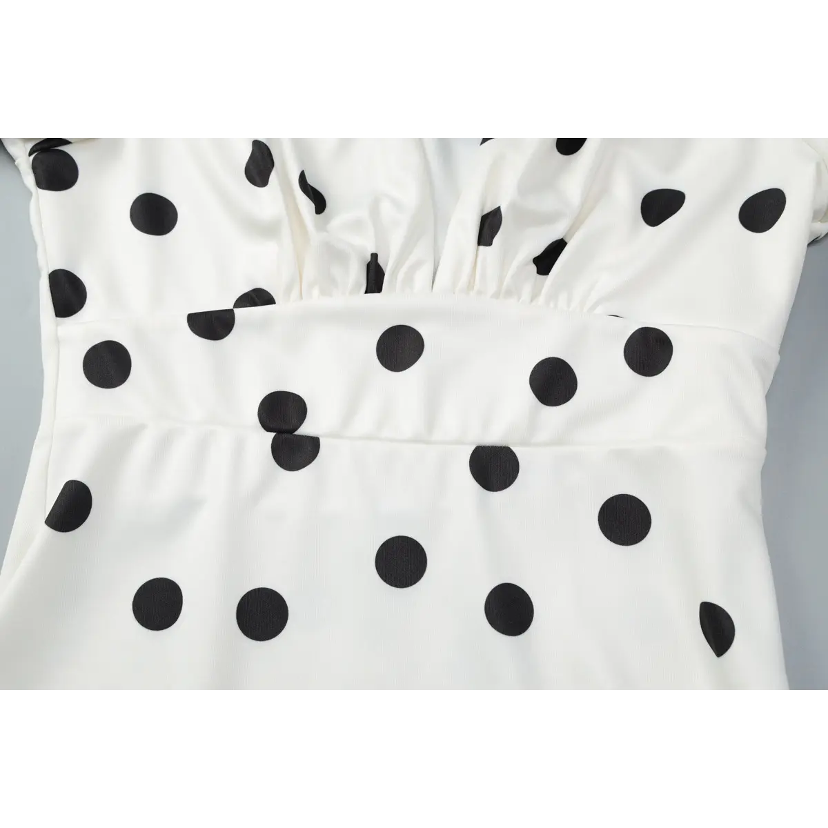 Close-up view of the gathered bust detail, defined waistline, and polka dot print alignment.