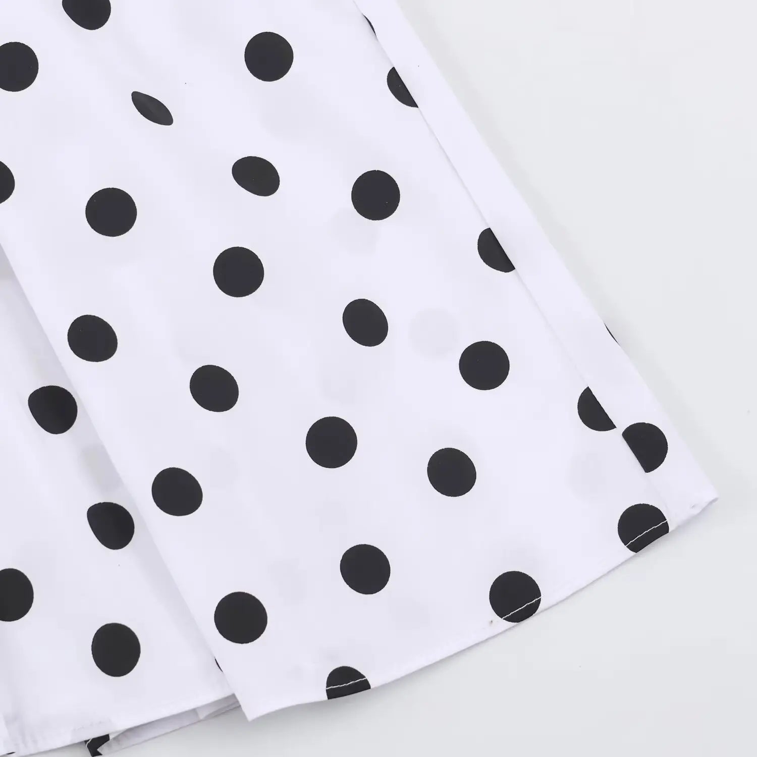 Close‑up of finished bottom hem edge on white black polka dot maxi dress