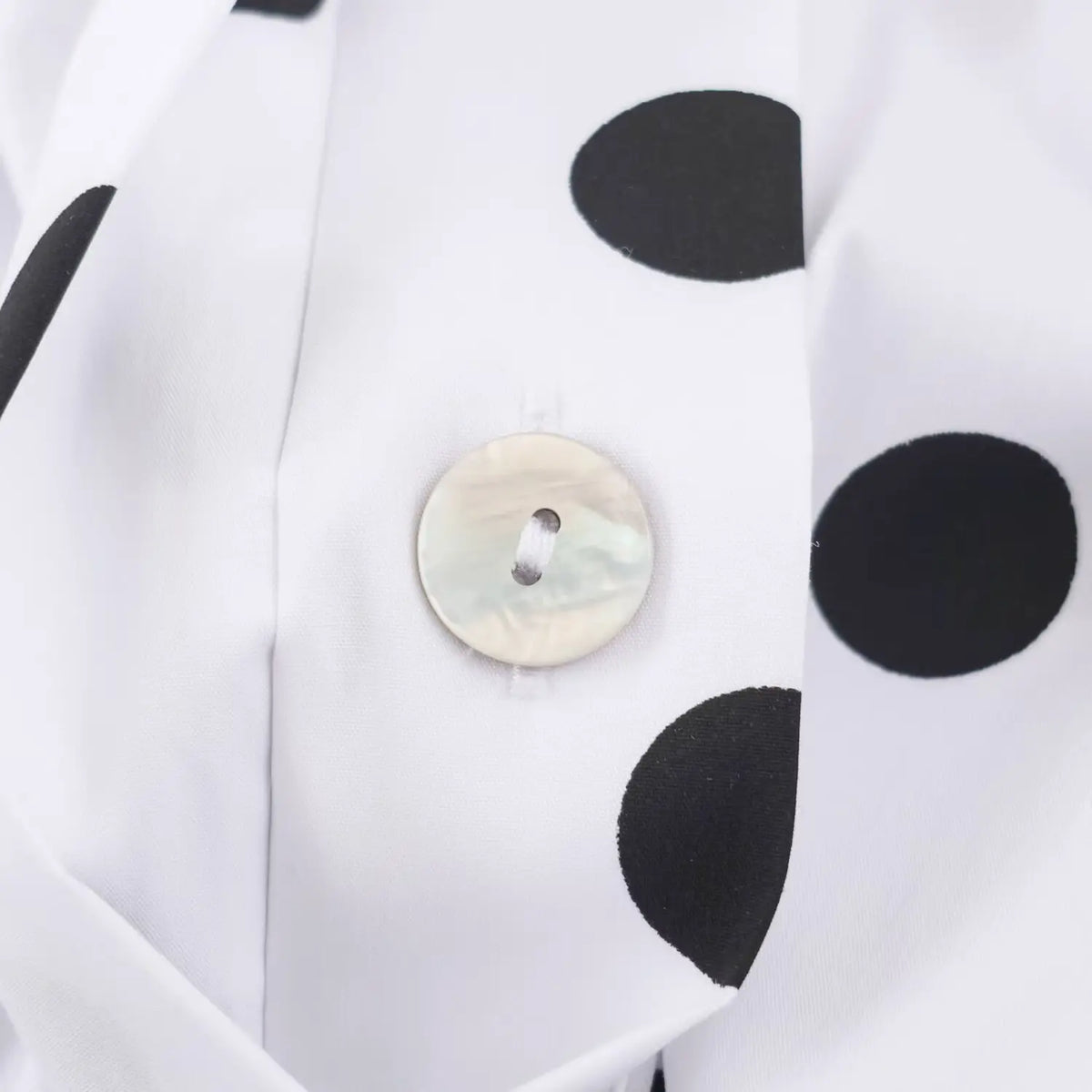 Close‑up shell button detail on white black polka dot sleeveless maxi dress