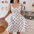 White base big black polka dot square neck mini cami dress, lace trim neck high waisted a-line skirt, half body korean indoor model shot holding pearl straw bag