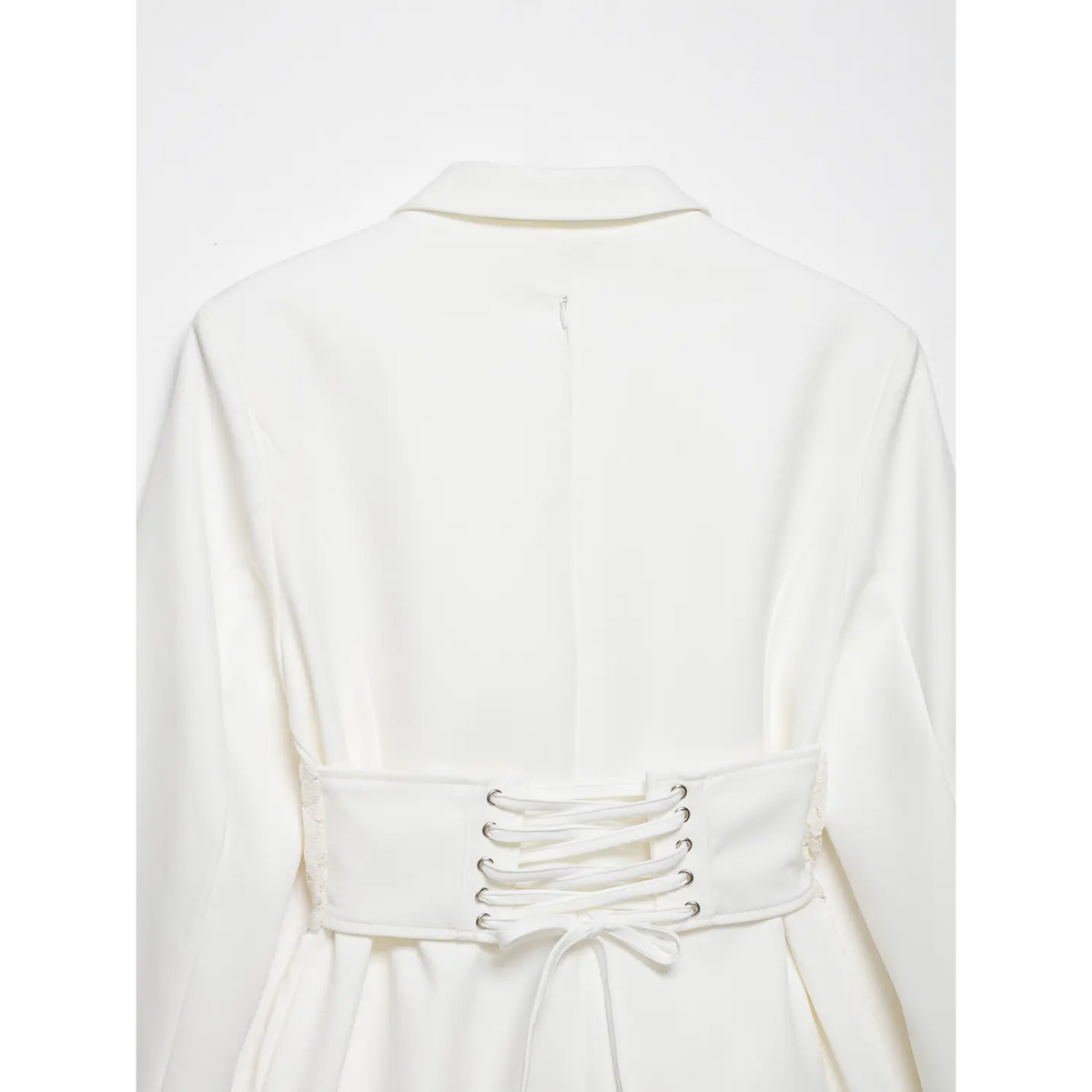 Back close-up of white blazer dress, lace-up corset belt with metal eyelets and bow tie