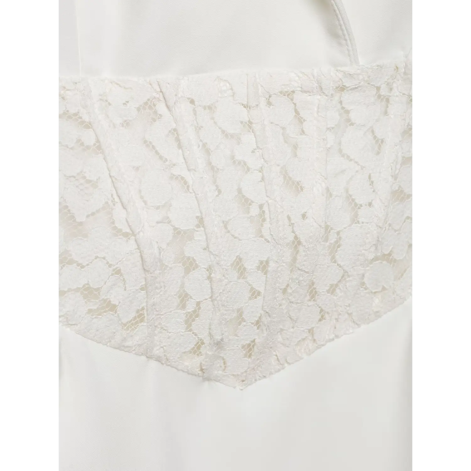 Close-up view of white floral lace corset waist panel on blazer mini dress, textured lace fabric