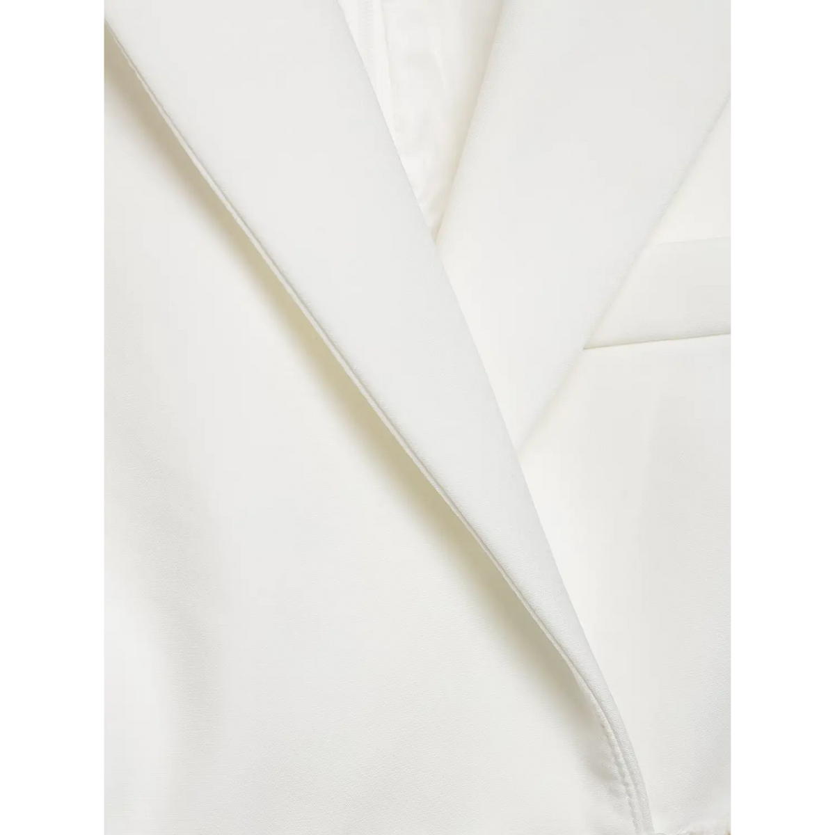 Extreme closeup of white blazer dress notched lapel, tailored stitching and premium fabric texture