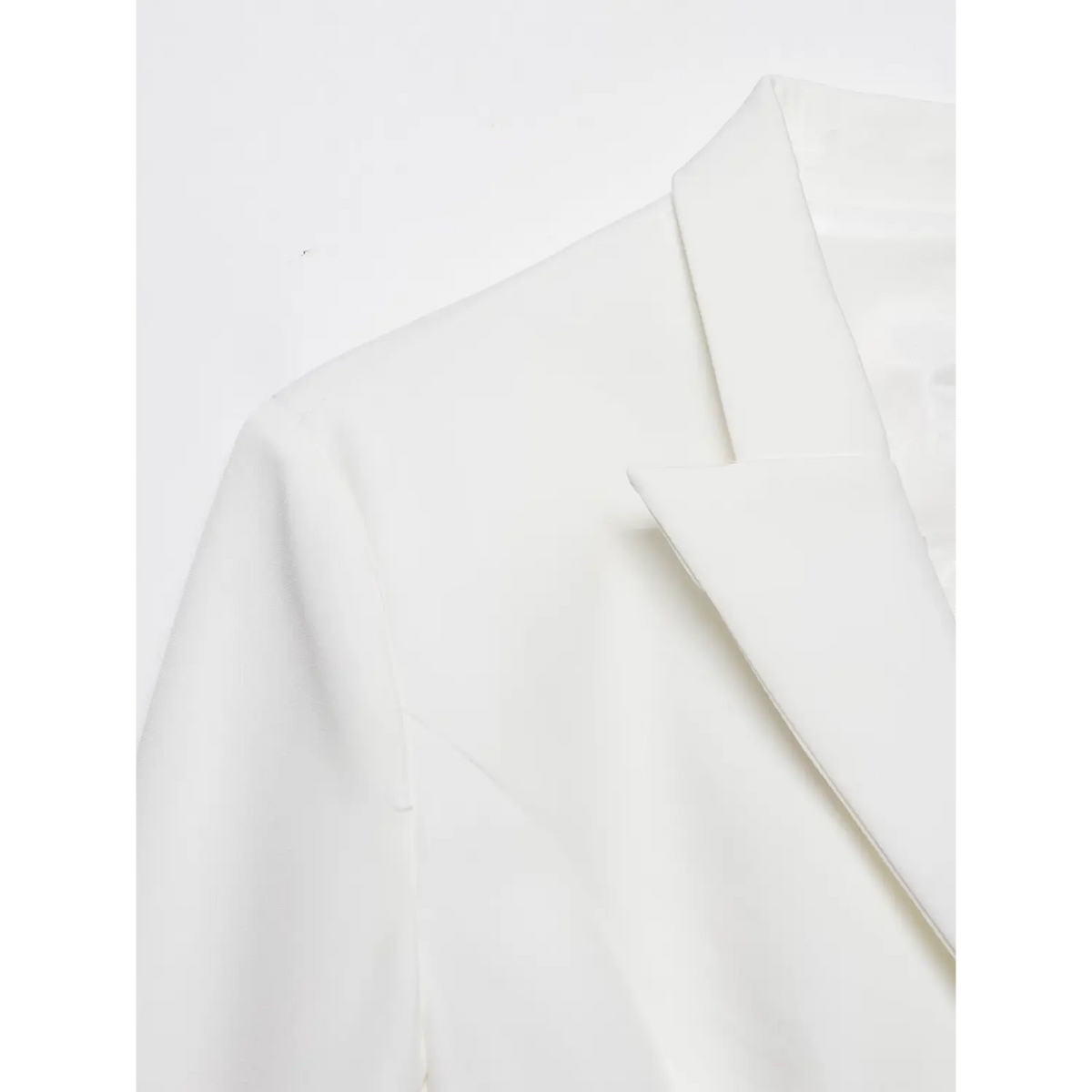 Macro detail of white blazer dress shoulder and notched lapel, smooth woven fabric texture