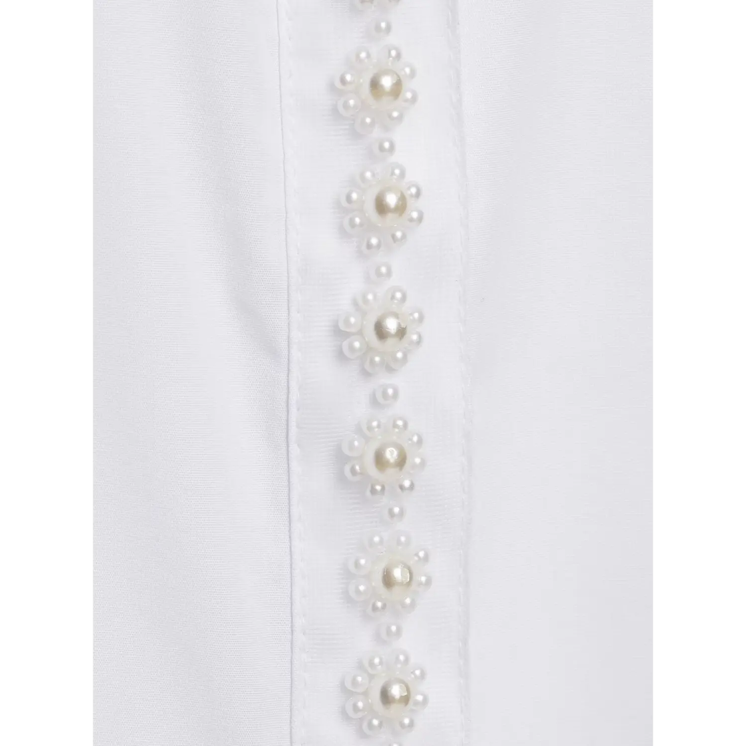 Macro shot flower shaped pearl embellishment on shirt placket